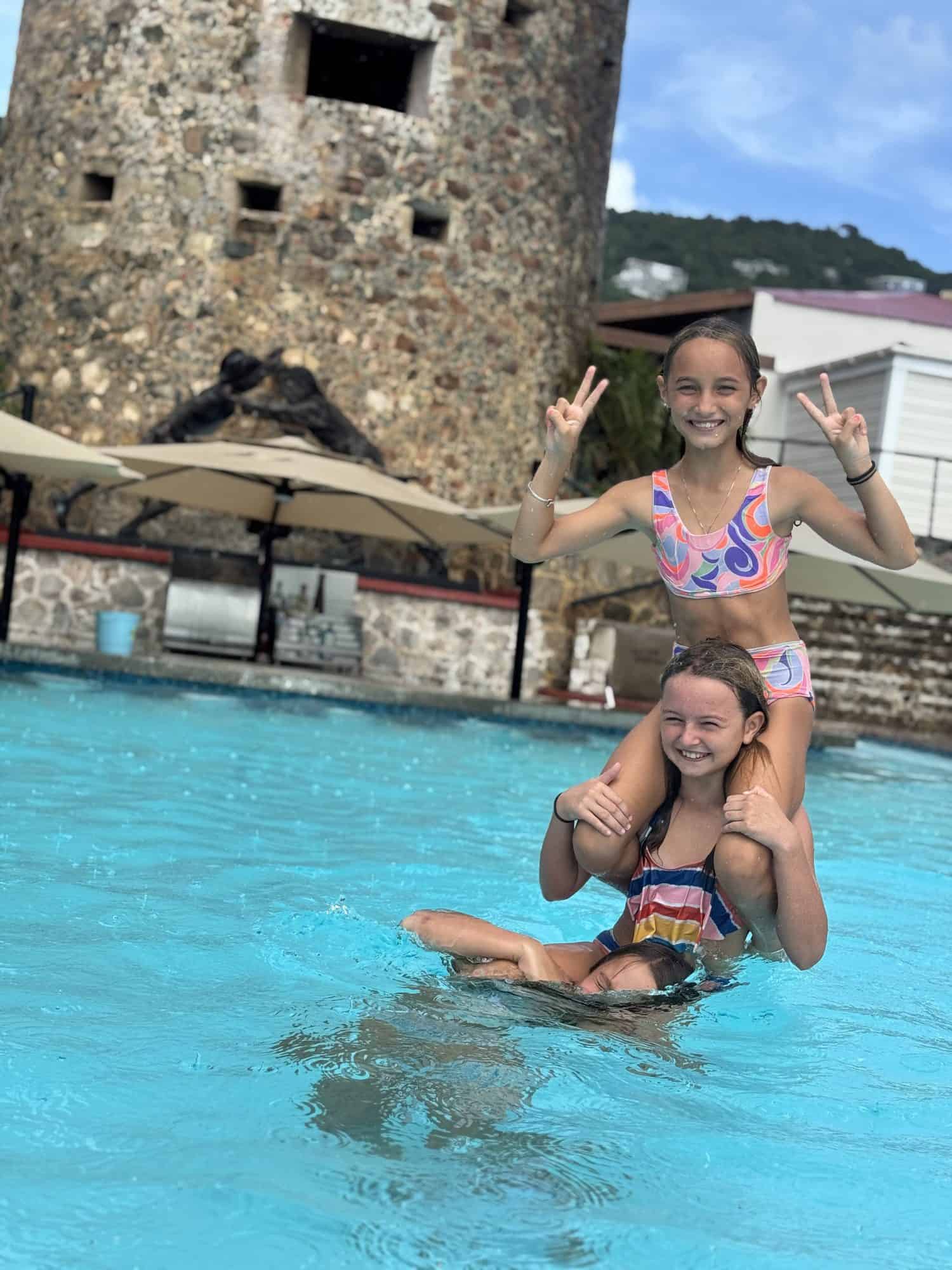 Family enjoying one of the best things to do in St. Thomas with kids, swimming in the pool at Blackbeard's Castle below the 1679 Skytsborg tower