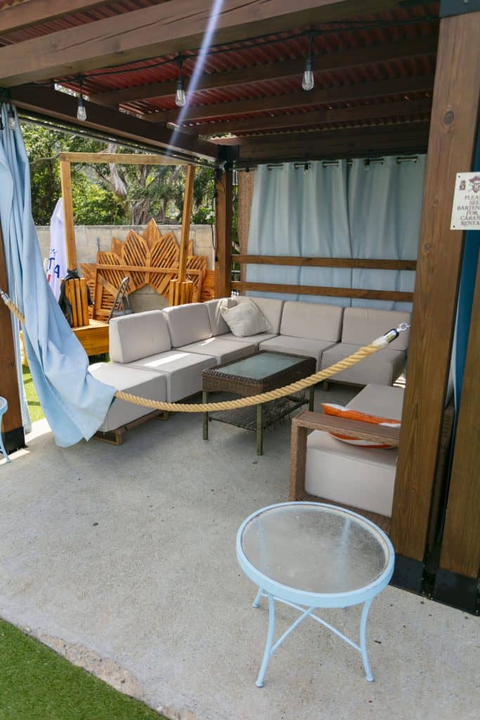 Relaxing outdoor lounge with sofa, table, and shaded area at Blackbeard's Castle.