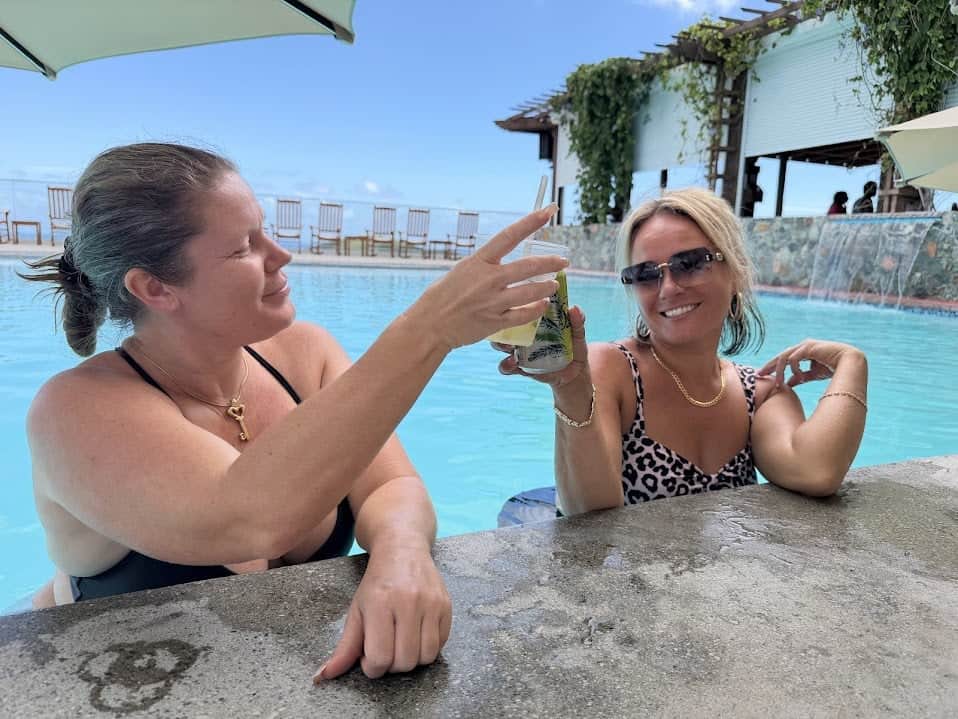 Two women enjoying drinks at Blackbeard's Castle poolside.