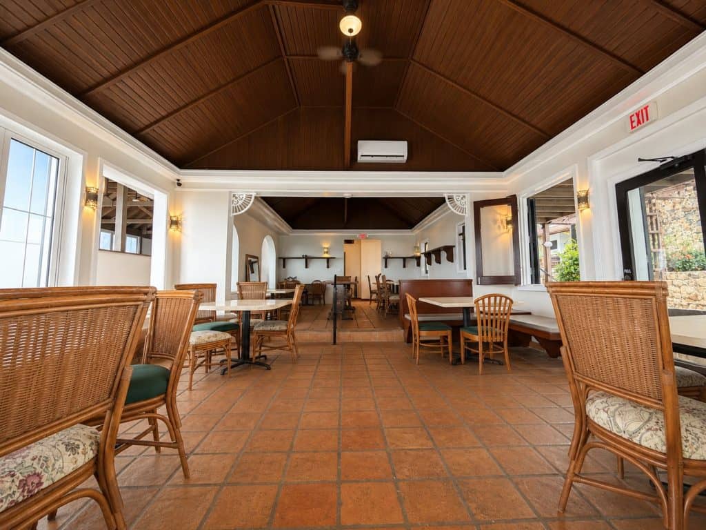 Spacious indoor dining room with wooden ceiling and wicker chairs at Blackbeard's Castle.